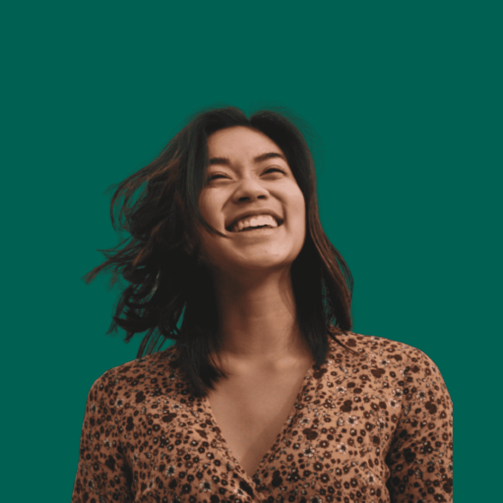 Joyful girl looking upwards with a bright smile, against a solid green background.
